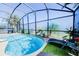 The relaxing screened-in pool includes a sun lounger, side table, and ample seating at 156 Carrera Ave, Davenport, FL 33897