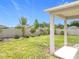 Well-manicured backyard with a covered patio, lush lawn, and privacy fence at 15865 Bradicks Ct, Clermont, FL 34711