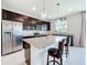 Modern kitchen with stainless steel refrigerator, granite countertops, and bar seating at 15865 Bradicks Ct, Clermont, FL 34711