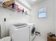 Functional laundry room with modern washer and dryer, shelving, and natural light at 15865 Bradicks Ct, Clermont, FL 34711