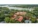 Aerial view of a large lakeside home with lush greenery and a boat gliding on the water at 1602 Alabama Dr # Ph404, Winter Park, FL 32789