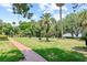 Scenic backyard with a brick path, green lawn, and mature trees, creating a serene outdoor space at 1602 Alabama Dr # Ph404, Winter Park, FL 32789