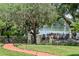 Lush backyard with a brick path leading to a tranquil lake view, framed by mature trees at 1602 Alabama Dr # Ph404, Winter Park, FL 32789