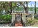 Picturesque view of a lake framed by trees, viewed from a brick path and an iron gate at 1602 Alabama Dr # Ph404, Winter Park, FL 32789