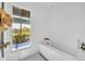 Bright bathroom featuring soaking tub, gold fixtures, mosaic tile, and a window view at 1602 Alabama Dr # Ph404, Winter Park, FL 32789