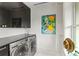 Well-lit laundry room with modern front-load washer and dryer, marble counters, and stylish artistic touches at 1602 Alabama Dr # Ph404, Winter Park, FL 32789