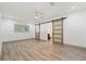 Spacious bedroom with laminate flooring, ceiling fan, and en suite bathroom with barn doors at 1623 Cumbie Ave, Orlando, FL 32804
