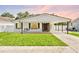 Beautiful single-story home featuring a covered front porch with a swing, lush lawn, and covered carport at 1623 Cumbie Ave, Orlando, FL 32804