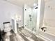 Renovated bathroom with glass shower enclosure, soaking tub, and modern black fixtures at 16334 Saint Augustine St, Clermont, FL 34714