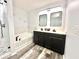 Updated bathroom showcasing a soaking tub, a walk-in shower, and double sink vanity with matte black fixtures at 16334 Saint Augustine St, Clermont, FL 34714