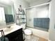 Bathroom featuring a glass door shower/tub, vanity, toilet, and storage shelves at 16334 Saint Augustine St, Clermont, FL 34714
