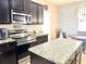 Kitchen featuring granite countertops, stainless steel appliances, dark cabinets, and a breakfast nook at 16334 Saint Augustine St, Clermont, FL 34714