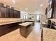 Open kitchen featuring granite countertops, stainless steel appliances, dark cabinets, and a center island at 16334 Saint Augustine St, Clermont, FL 34714