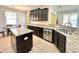Kitchen featuring granite countertops, stainless steel appliances, dark cabinets, and center island at 16334 Saint Augustine St, Clermont, FL 34714