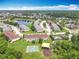 High aerial showcasing the community's amenities: playground, pool, lake and townhome residences at 16724 Cedar Crest Dr, Orlando, FL 32828