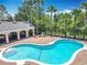 Community pool with sun loungers under covered patio, surrounded by trees and plantings at 16724 Cedar Crest Dr, Orlando, FL 32828