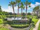 A well-maintained entrance sign by a pond, adorned with landscaping and palm trees at 16724 Cedar Crest Dr, Orlando, FL 32828