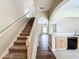 Inviting entryway boasts wood-look flooring, carpeted stairs, and arched openings to living spaces at 16724 Cedar Crest Dr, Orlando, FL 32828