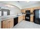 Functional kitchen featuring tile floors, wooden cabinets, and black appliances at 16724 Cedar Crest Dr, Orlando, FL 32828