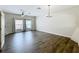 Spacious living room with hardwood floors, two windows, ceiling fan, and chandelier at 16724 Cedar Crest Dr, Orlando, FL 32828