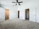 Spacious bedroom with neutral carpet, ceiling fan, and two entryways to closet and bathroom at 16724 Cedar Crest Dr, Orlando, FL 32828