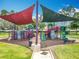 Community playground with multiple colorful play structures, slides, and shade covers at 16724 Cedar Crest Dr, Orlando, FL 32828
