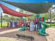 Community playground with multiple colorful play structures, slides, and shade covers at 16724 Cedar Crest Dr, Orlando, FL 32828