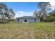Home's back exterior featuring sliding glass doors with a view of the large backyard at 16904 Sw 30Th Avenue Rd, Ocala, FL 34473