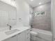 Bathroom with white vanity, shower-tub combo, and neutral tile at 16904 Sw 30Th Avenue Rd, Ocala, FL 34473
