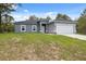 Single-story home featuring a two-car garage, gray exterior and a partial lawn at 16904 Sw 30Th Avenue Rd, Ocala, FL 34473