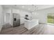 An open-concept kitchen boasts stainless steel appliances, white cabinets, and an island with backyard access at 16904 Sw 30Th Avenue Rd, Ocala, FL 34473