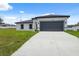 Well-maintained home with a long driveway leading to a two-car garage, set against a blue sky at 17139 Sw 44Th Cir, Ocala, FL 34473