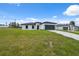 Well-maintained home with a long driveway leading to a two-car garage, set against a blue sky at 17139 Sw 44Th Cir, Ocala, FL 34473