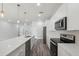 Modern kitchen featuring white cabinets, stainless steel appliances, and a large island with quartz countertops at 17139 Sw 44Th Cir, Ocala, FL 34473