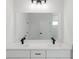 Bright primary bathroom boasts dual sinks, sleek black faucets, and a large framed mirror at 17434 Sw 36Th Avenue Rd, Ocala, FL 34473