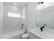 Bright bathroom features a tub with marble surround, a black faucet, and a white vanity at 17434 Sw 36Th Avenue Rd, Ocala, FL 34473