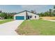 New construction home with a modern exterior, blue garage door, and freshly installed lawn at 17434 Sw 36Th Avenue Rd, Ocala, FL 34473