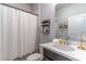 Cozy bathroom featuring modern fixtures, a stylish vanity, and a shower with a white curtain at 17840 Passionflower Cir, Clermont, FL 34714