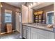 Bright bathroom featuring dual sinks, granite countertops, stylish cabinets, and a glass-enclosed shower at 17840 Passionflower Cir, Clermont, FL 34714