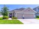 Charming single-Gathering home featuring a two-car garage, well-manicured lawn, and inviting front entryway at 17840 Passionflower Cir, Clermont, FL 34714