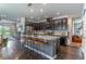 Modern kitchen with stainless steel appliances, dark cabinetry, a large island and barstool seating at 17840 Passionflower Cir, Clermont, FL 34714