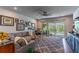 Bright living room featuring comfortable seating, stylish decor, and sliding glass doors to the outdoor pool area at 17840 Passionflower Cir, Clermont, FL 34714