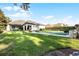Spacious backyard featuring a pool, lush green lawn, mature trees, and the home's exterior at 190 Osprey Hammock Trl, Sanford, FL 32771