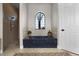 Luxury bathroom with a soaking tub, arched window, and a separate shower area at 190 Osprey Hammock Trl, Sanford, FL 32771