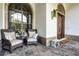 Inviting front porch with comfortable chairs, decorative pillows, and a charming welcome mat at 190 Osprey Hammock Trl, Sanford, FL 32771