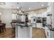 Open kitchen featuring custom white cabinets, granite counters, stainless appliances, an island, and pendant lighting at 190 Osprey Hammock Trl, Sanford, FL 32771