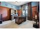 Spacious office with wood paneling, large window, custom desk, and built-in storage at 190 Osprey Hammock Trl, Sanford, FL 32771