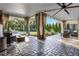Covered patio with stone flooring, elegant drapes, and comfortable seating overlooking the pool at 190 Osprey Hammock Trl, Sanford, FL 32771