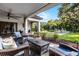 A covered patio area with stylish outdoor seating and serene view of a lush backyard at 190 Osprey Hammock Trl, Sanford, FL 32771