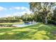 Tranquil pool area surrounded by lush greenery, mature trees, and well-maintained landscaping at 190 Osprey Hammock Trl, Sanford, FL 32771